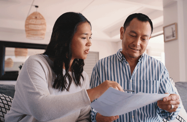 A woman and man look over financial documents.
