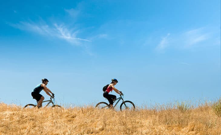 Couple Riding Mountain Bikes on a Trail