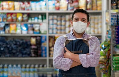 A shop owner wearing a mask.