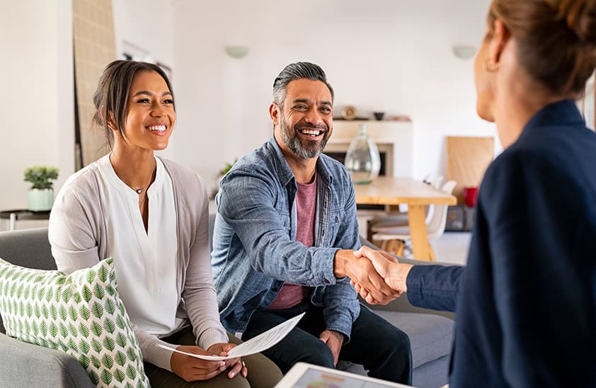 A couple shaking hands with an insurance agent.