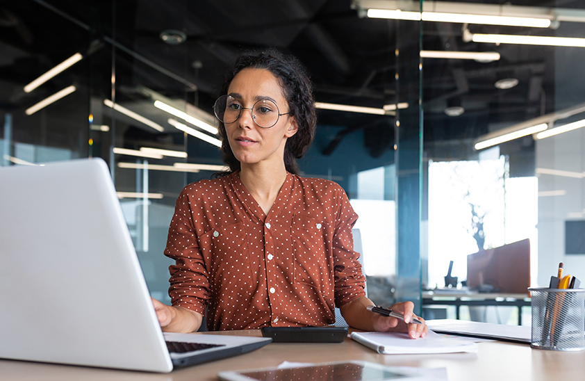 woman in office looking at laptop screen in office