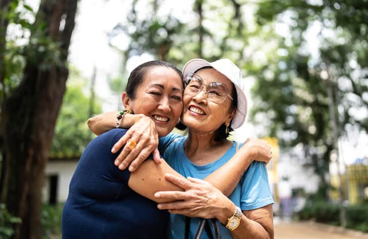 A happy Asian family hugging.