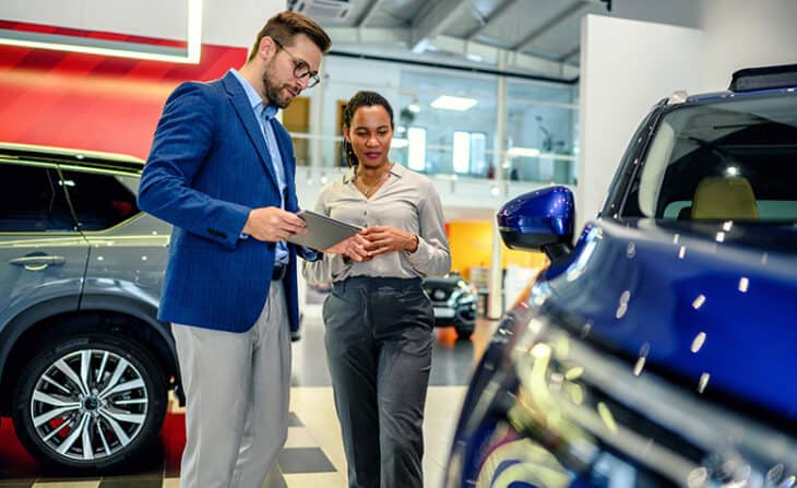 shopping for a new car on showroom floor with salesperson