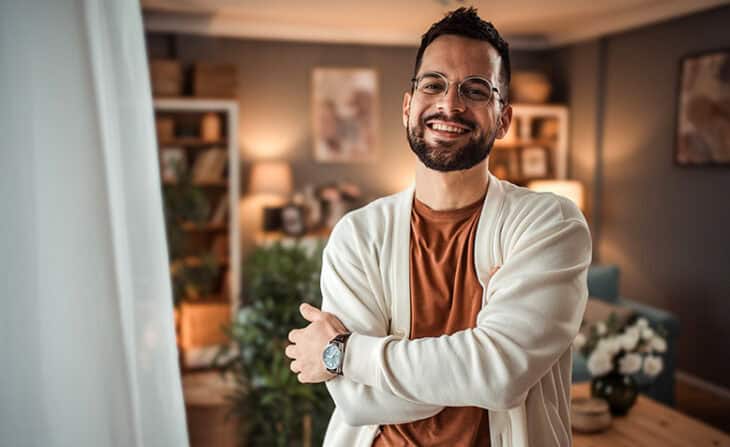 confident and happy young man at home wearing a cardigan