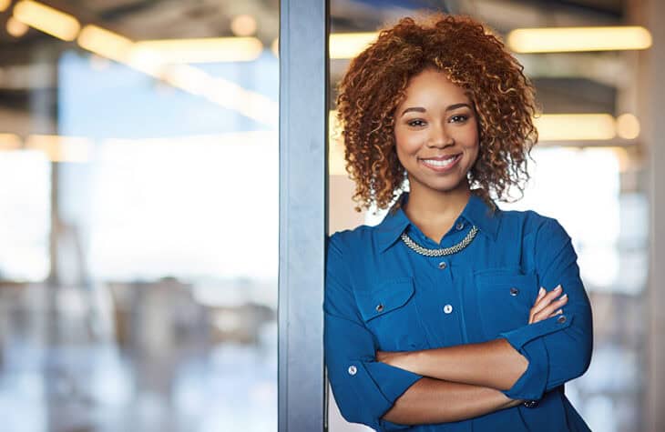 A young and confident businesswoman smiling at the camera.
