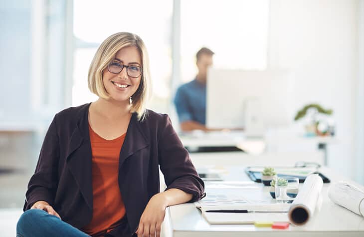 A confident woman sitting at her workspace.