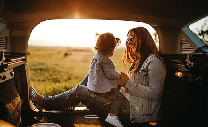 Mom and daughter enjoying a road side rest near a beautiful field in their RV