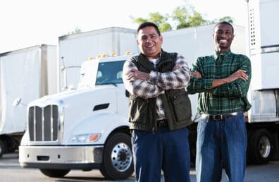 Two business partners standing in front of a semitruck.