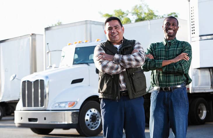 Two business partners standing in front of a semitruck.