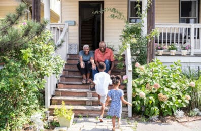 Happy seniors welcoming visiting grandchildren