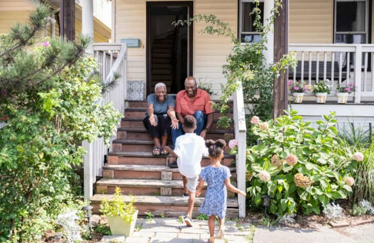Happy seniors welcoming visiting grandchildren